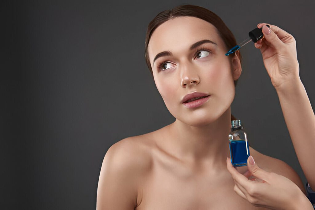 Image of a woman demonstrating how to use the kiehl's midnight anti-aging serum